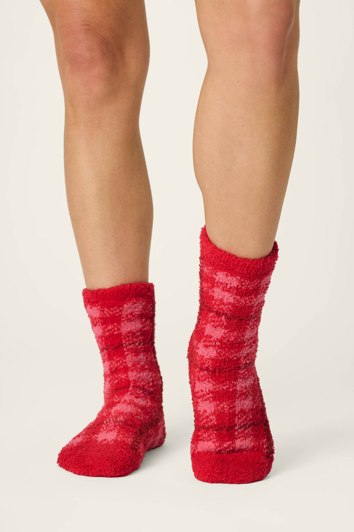 A person wears P.J. Salvage Red Plaid with Embroidered Bow Socks, standing on a white background with only their legs visible from the knees down.