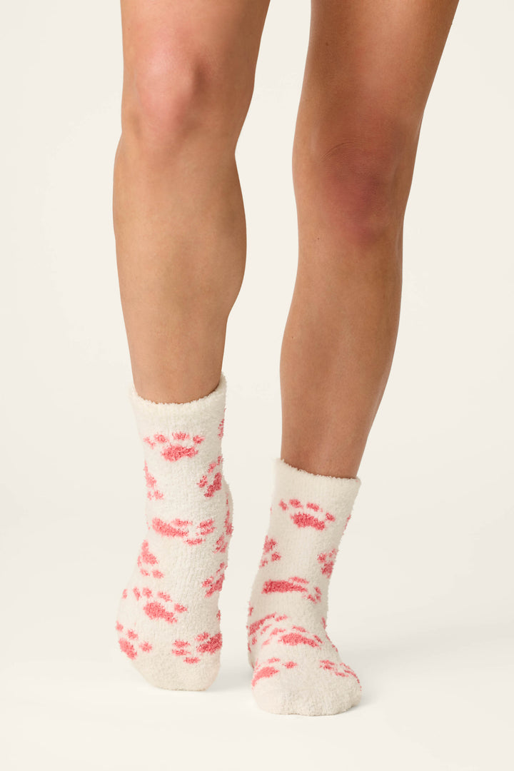 A person is standing against a plain background wearing P.J. Salvage Pink Paw Print Socks.