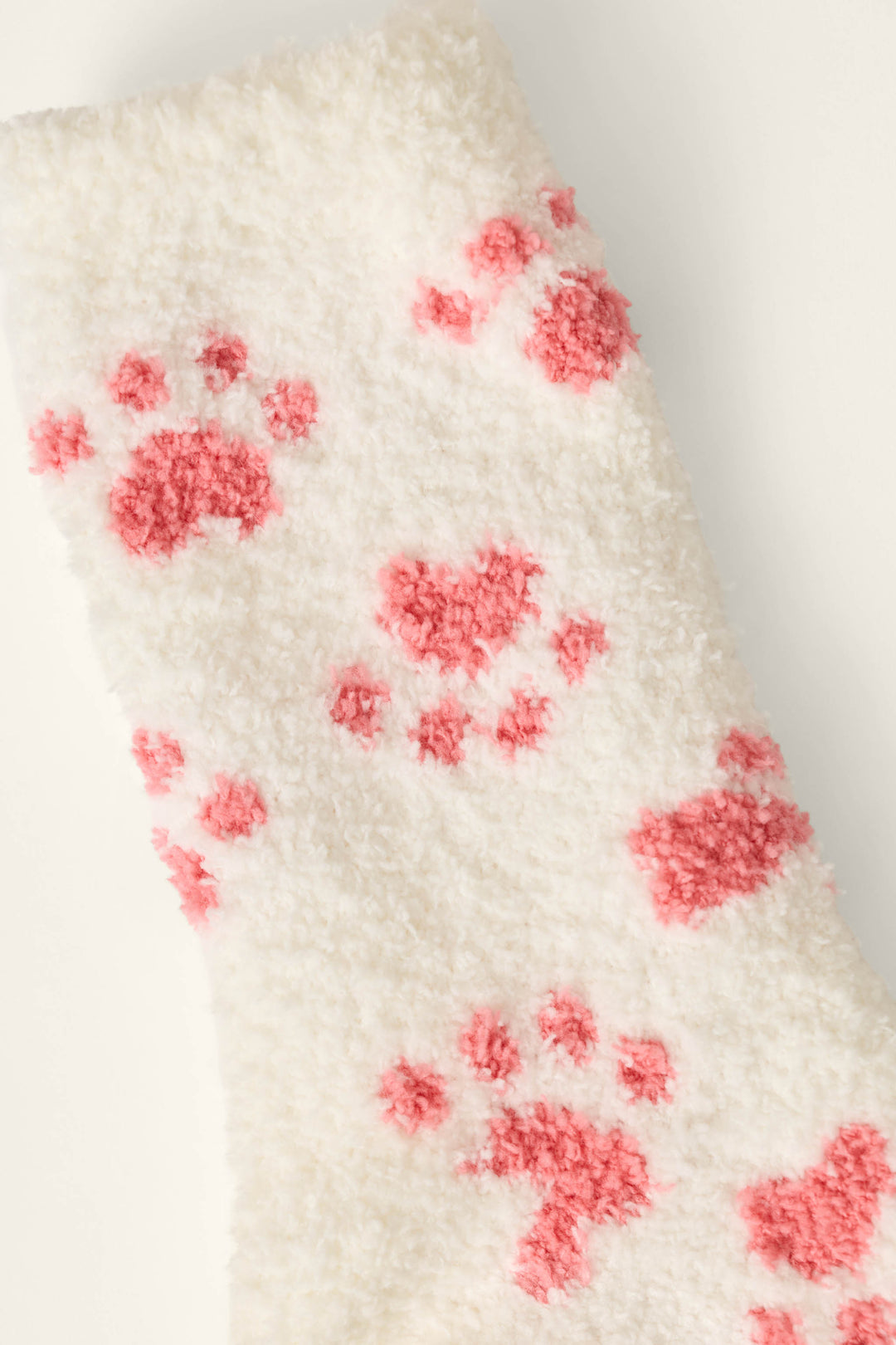 P.J. Salvage Pink Paw Print Socks feature a fuzzy white fabric adorned with a playful pink animal paw prints pattern, offering the cozy comfort of soft socks or a plush blanket.