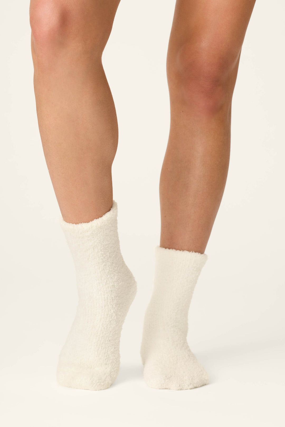 A person wears P.J. Salvage Holiday Martini Embroidered Socks and stands on a light background with their legs slightly crossed at the ankles.