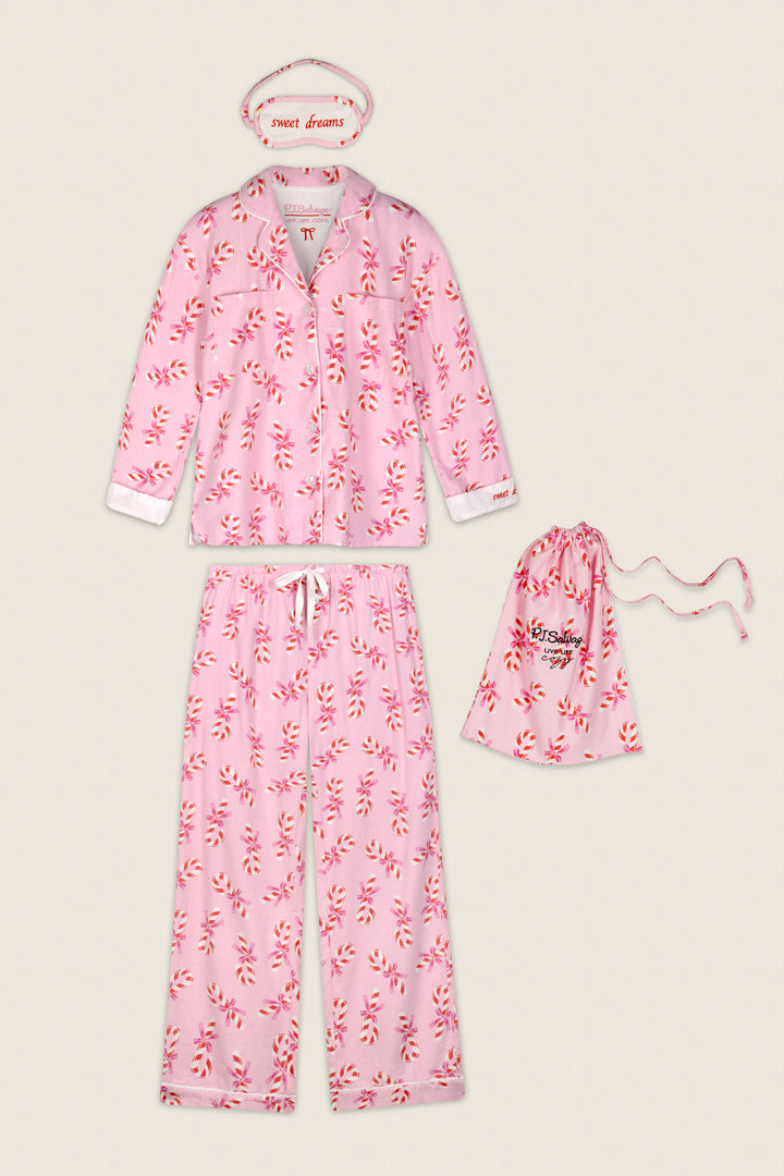 The Sweeter Than Sugar Candy Cane Print 4-Piece PJ Set by P.J. Salvage features a pink pajama set with a playful red and white candy cane print, including a long-sleeve top, pants, matching drawstring pouch, and a “sweet dreams” eye mask—all displayed on a beige background.