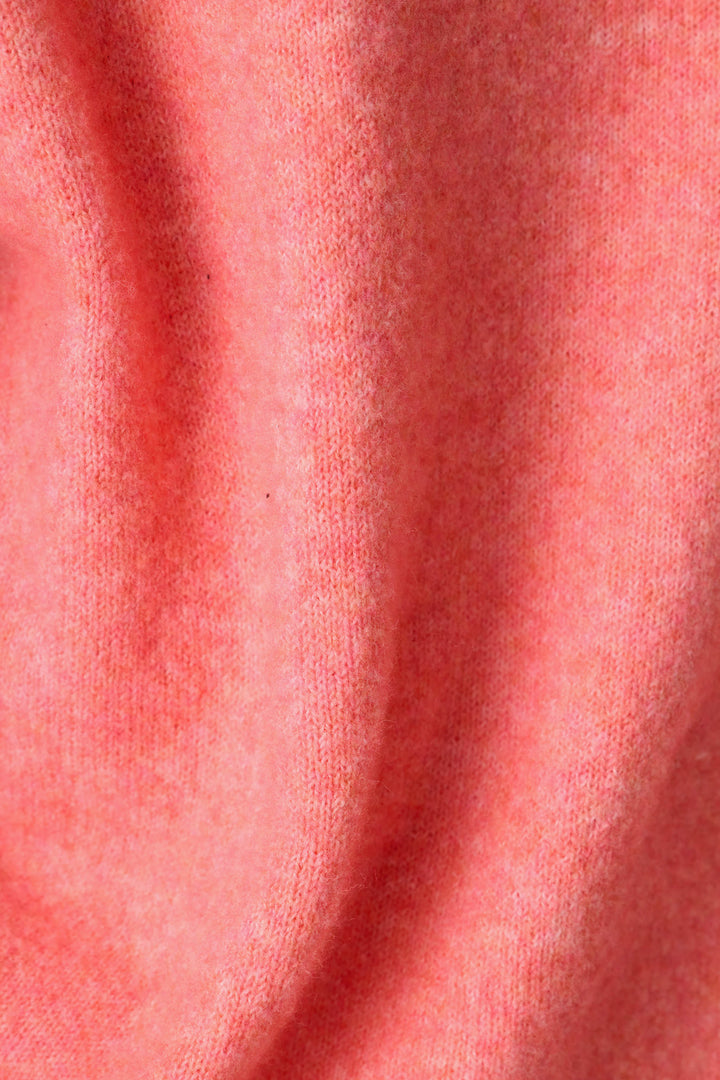 A close-up of the Mimosa Please Snuggle Sweater by P.J. Salvage showcases its soft pink fabric with a slightly fuzzy texture and gentle folds, revealing subtle shading and highlights across the surface.