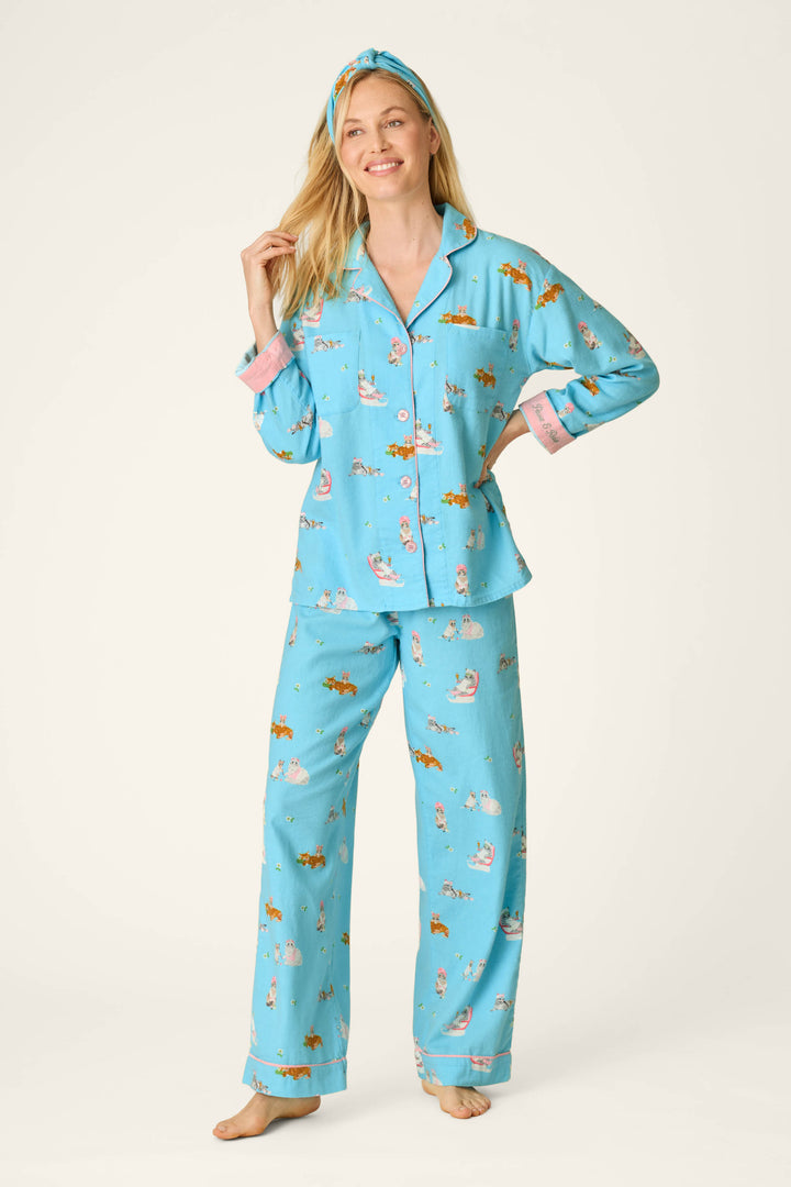 A woman stands barefoot and smiling against a plain light background, wearing the P.J. Salvage Pampered Cat Print 3-Piece Long Sleeve Flannel PJ Set with matching headband.