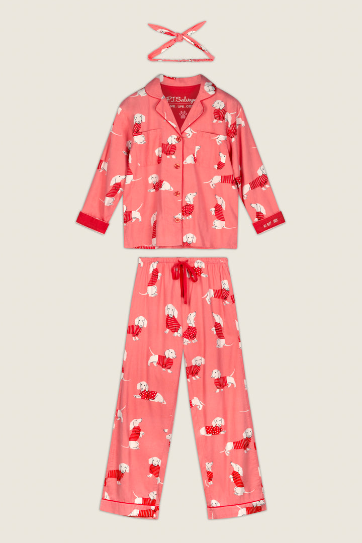 The P.J. Salvage Dachshund Print 3-Piece Flannel PJ Set features a pink long-sleeve button-up top, matching pants, and a coordinating eye mask, all adorned with an adorable dog print and displayed on a plain background.