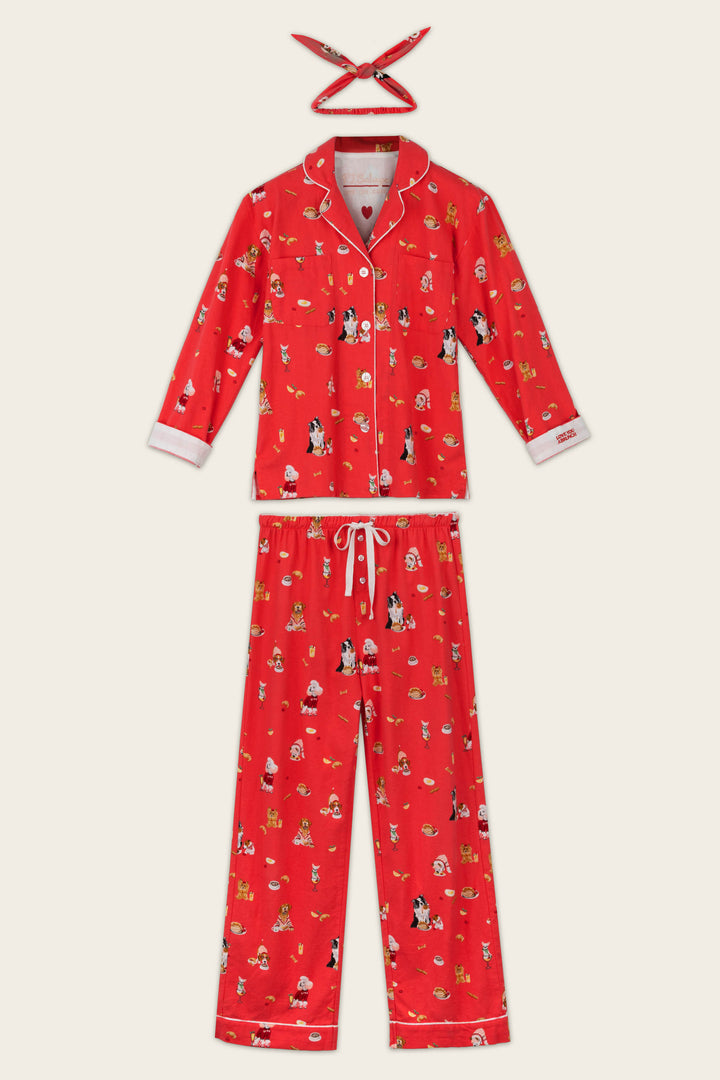 The P.J. Salvage Dogs Who Brunch Print 3-Piece Long Sleeve Flannel PJ Set, shown laid out flat on a light background, features a red pajama top with white piping and playful cartoon dog prints, matching drawstring pants, and a coordinating headband.