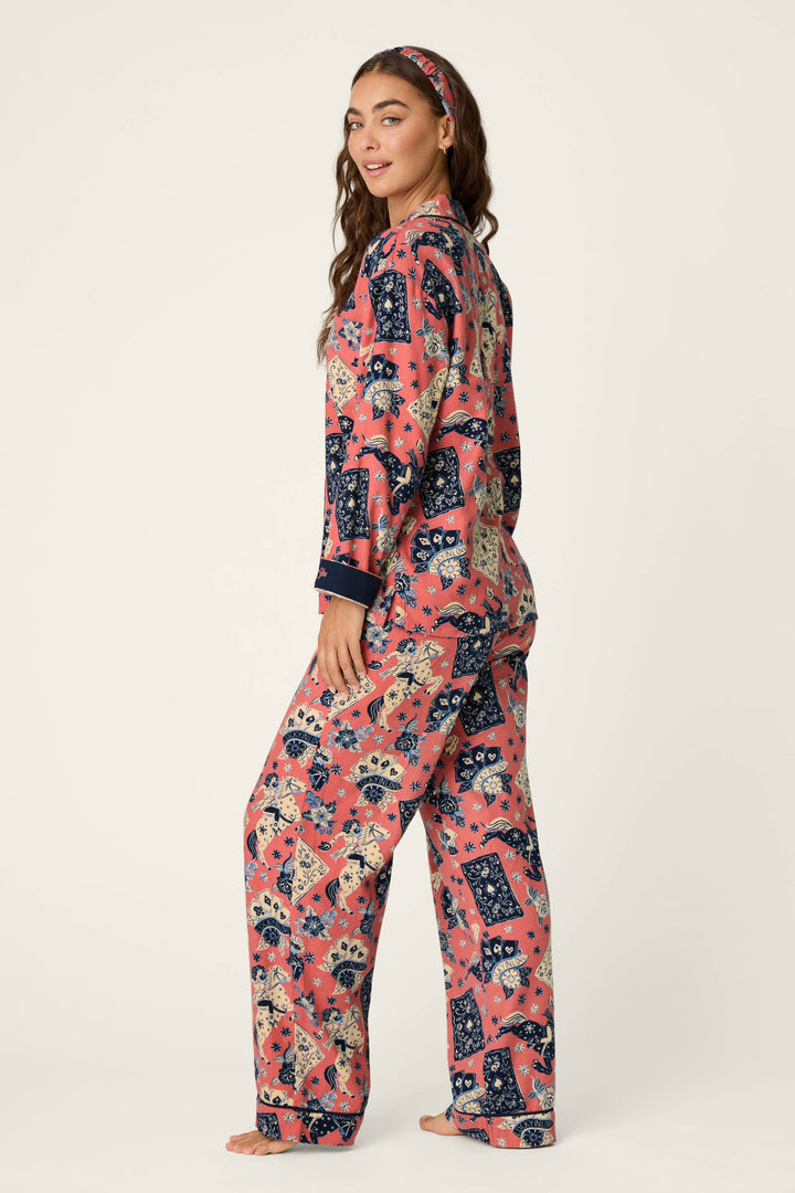 A woman stands barefoot against a plain background, smiling over her shoulder while wearing the P.J. Salvage Lucky in Love Western Print 3-Piece Long Sleeve Flannel PJ Set and a matching headband.