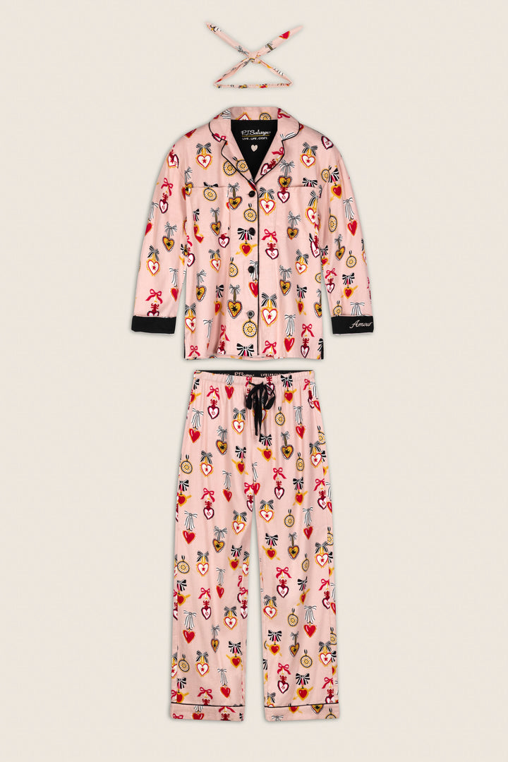 The Love Lockets Print 3-Piece Long Sleeve Flannel PJ Set by P.J. Salvage includes a pink jacket, pants, and a matching headband, all adorned with colorful heart, crown, and gemstone prints, and finished with black trim and buttons.