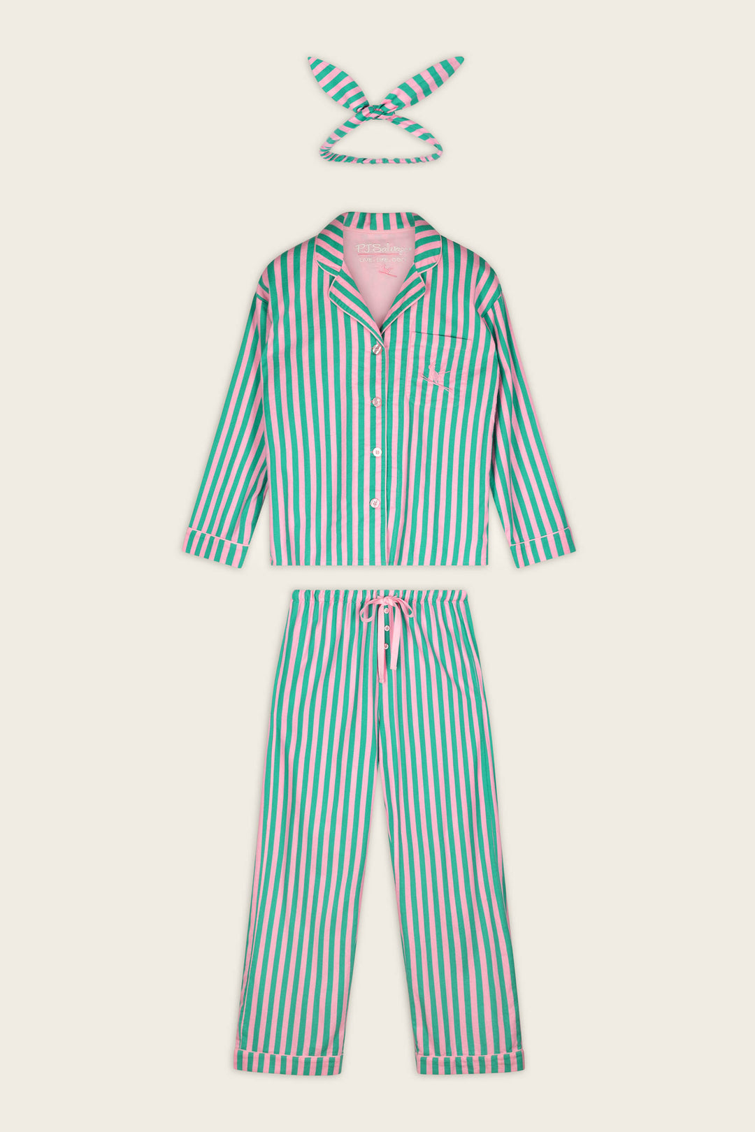 The P.J. Salvage Ski Bunny Icon 3-Piece Long Sleeve Flannel PJ Set includes a button-up long-sleeve top, matching drawstring pants, and a coordinating fabric headband. The set features vertical green, pink, and white stripes and is laid flat on a cream background.