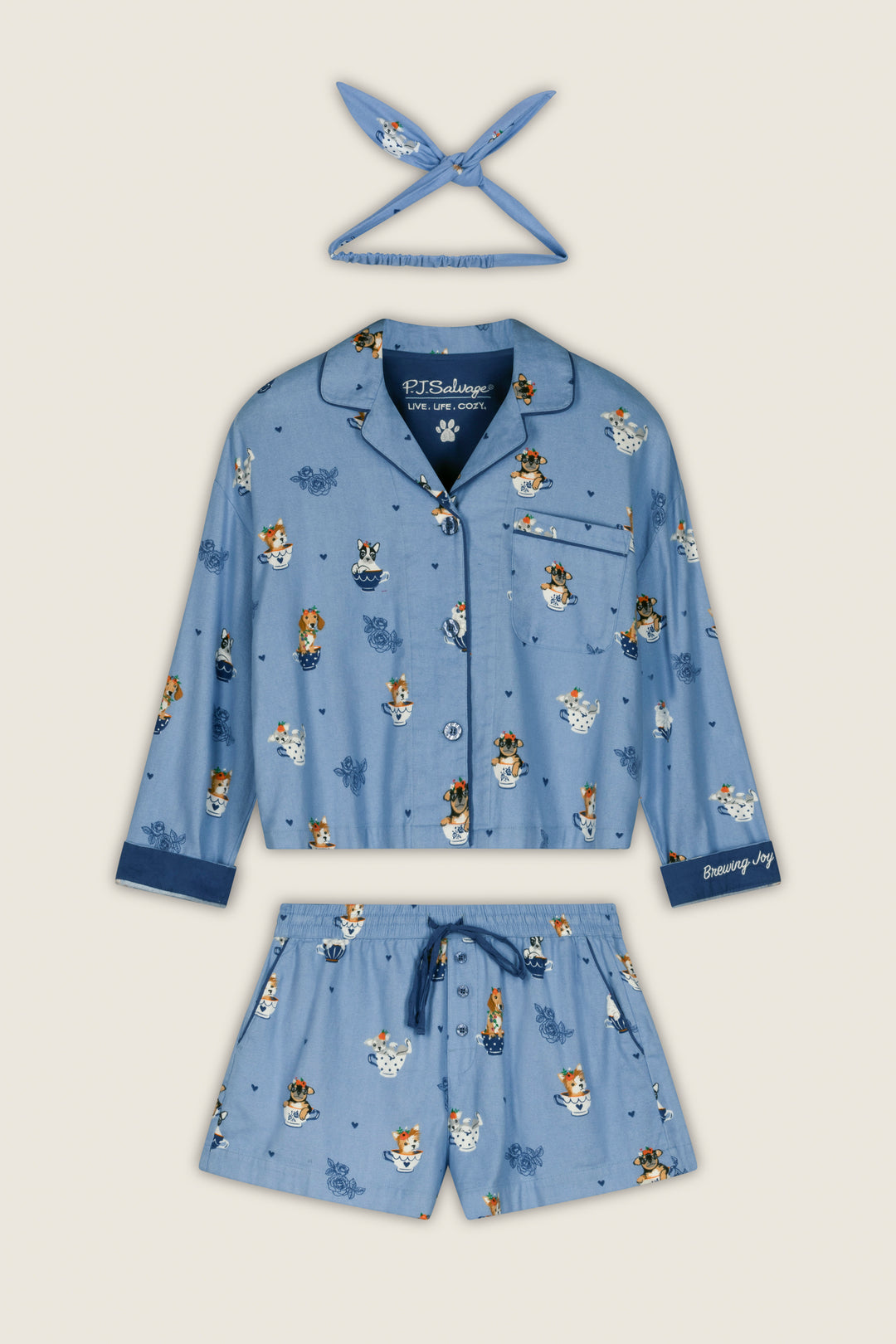 The Teacup Pups 3-Piece Short Flannel PJ Set by P.J. Salvage features a playful dog print on a light background and includes a long-sleeve button-up top, drawstring shorts, and a coordinating headband.