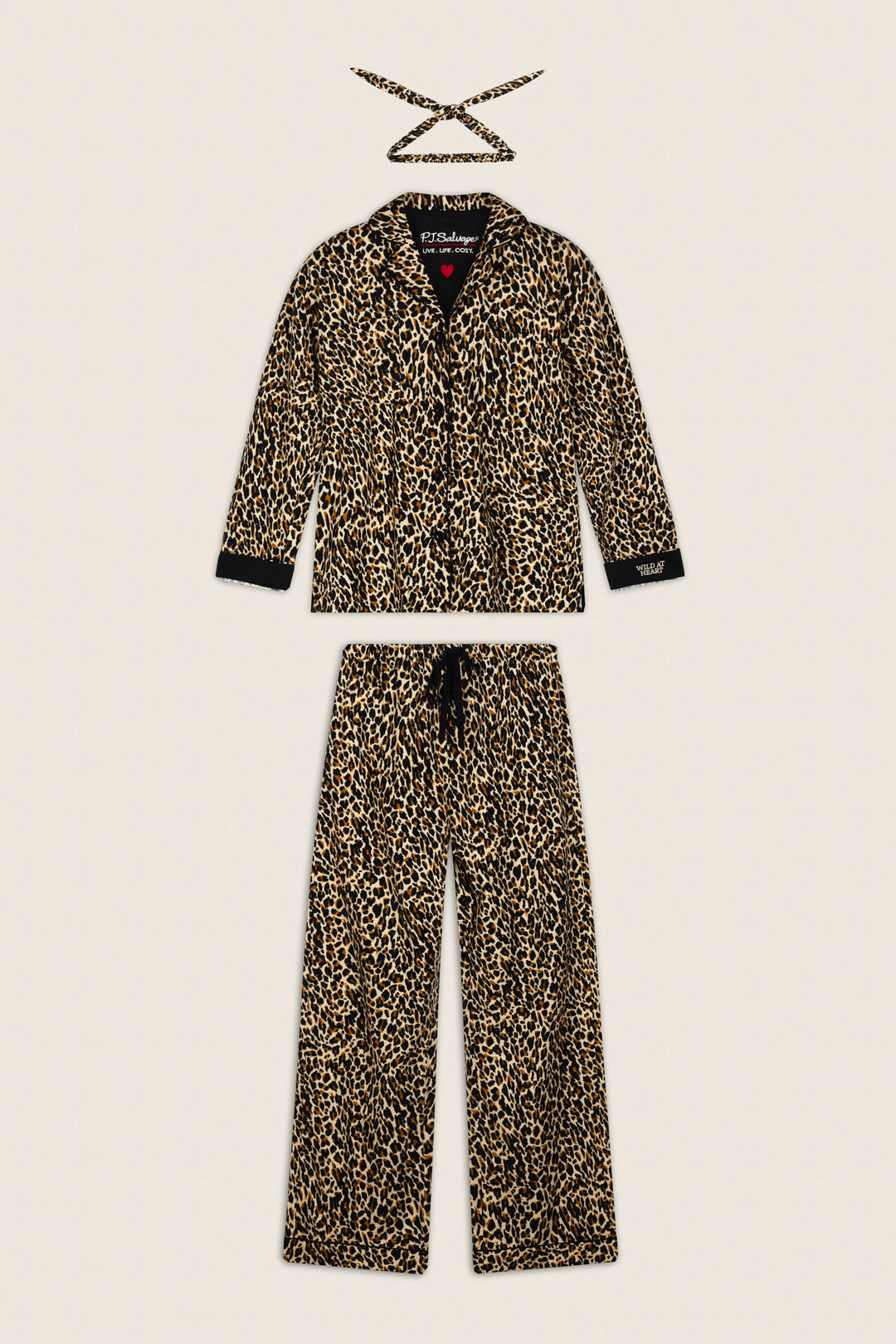 The P.J. Salvage Wild At Heart Leopard Print 3-Piece Flannel PJ Set, featuring a long-sleeve button-up top, matching pants, and a coordinating sleep mask, is displayed flat on a light beige background.