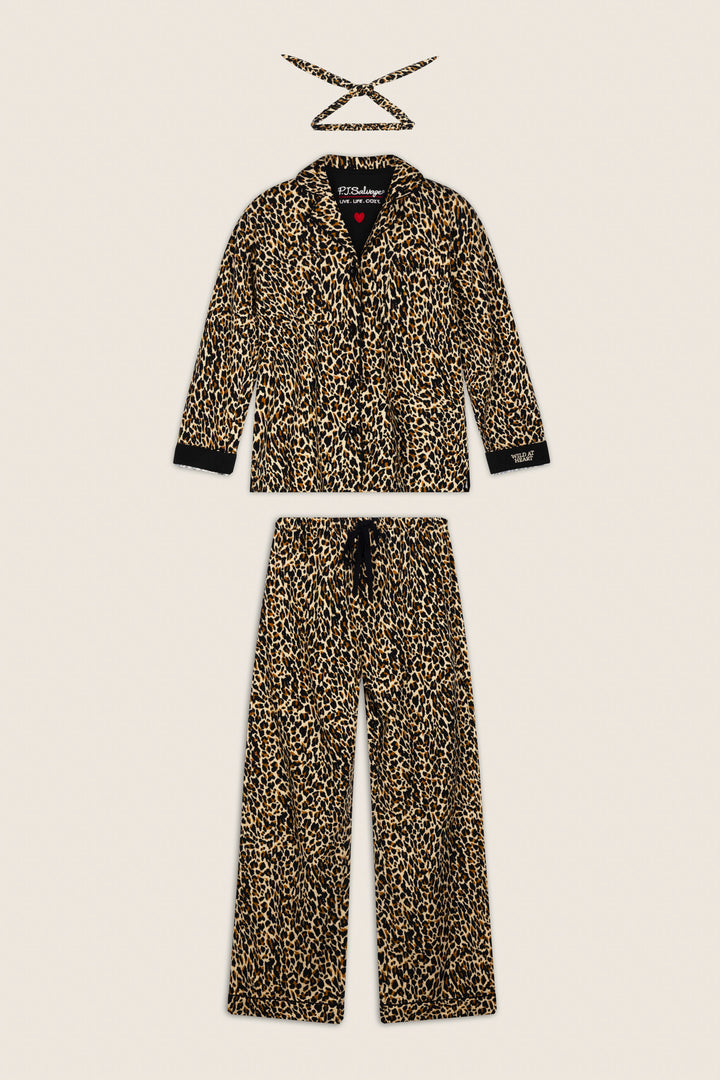 The P.J. Salvage Wild At Heart Leopard Print 3-Piece Flannel PJ Set, featuring a long-sleeve button-up top, matching pants, and a coordinating sleep mask, is displayed flat on a light beige background.