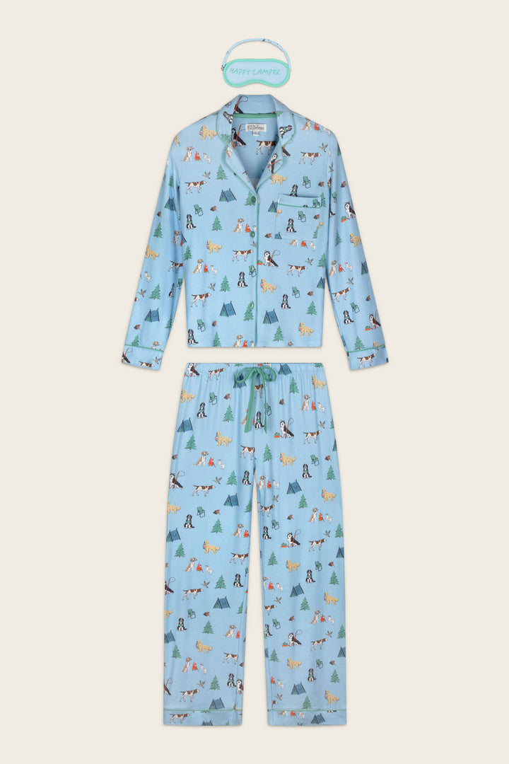 The Happy Campawr Dogs Camping Print 3-Piece PJ Set by P.J. Salvage features a light blue pajama set with long sleeves and pants, adorned with playful camping-themed prints such as tents, trees, animals, and campers. Displayed flat with a “Happy Camper” label above.