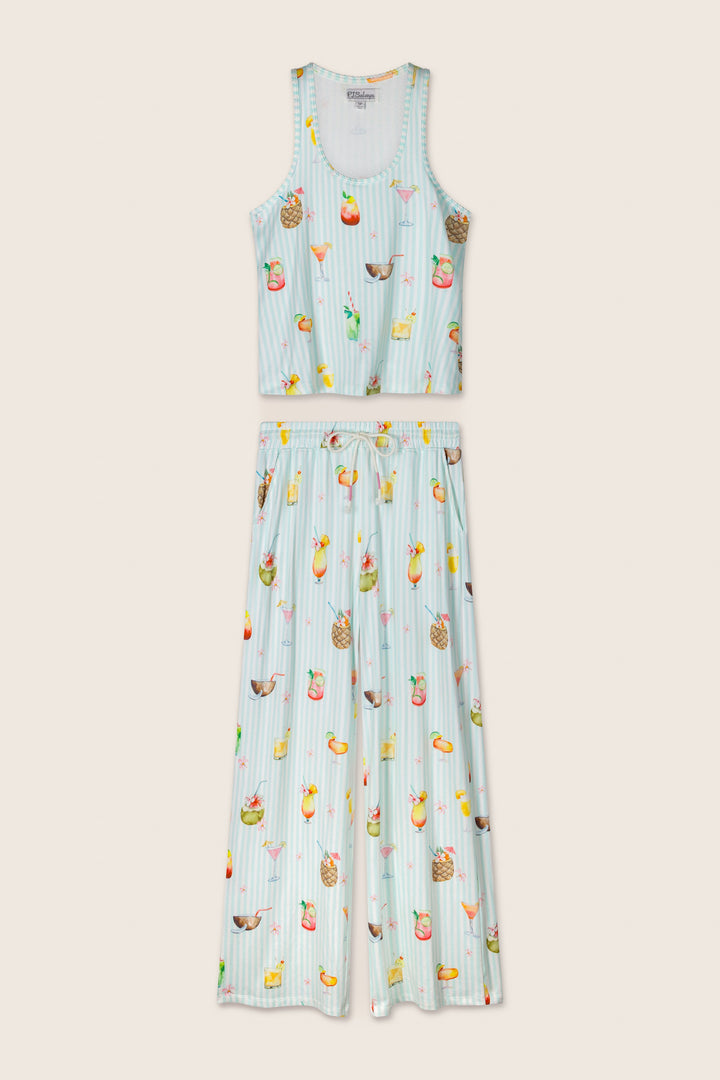 The P.J. Salvage "It's Five O'clock Somewhere" Cocktail Print Long PJ Set features a sleeveless, cropped tank top and wide-leg pants with thin blue and white stripes and a vibrant fruit and drink motif, displayed flat on a neutral background.