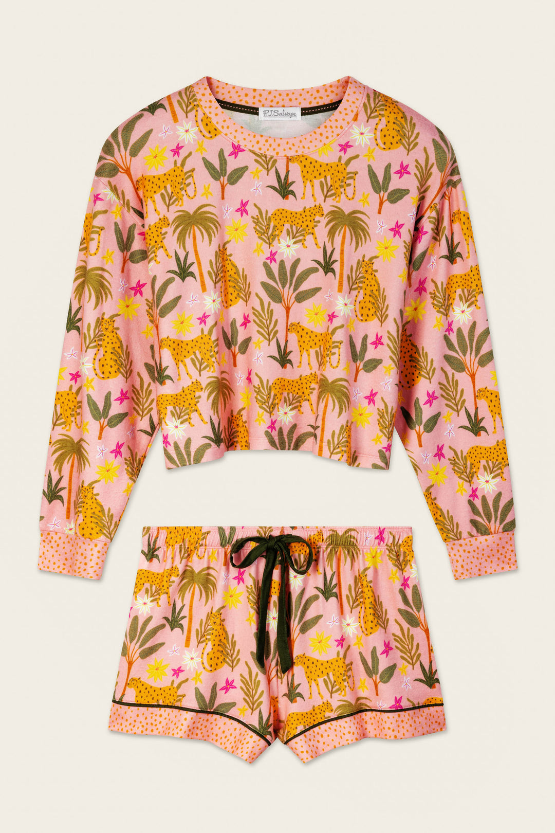 The P.J. Salvage In the Jungle Leopard Safari Short PJ Set includes a long-sleeve top and shorts in peachy jersey with a pink background, yellow leopards, palm trees, pink flowers, black drawstring, and black trim.