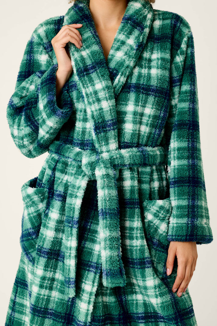 A person models the P.J. Salvage Let’s Get Cozy Plaid Robe, featuring a green and blue plaid pattern, pockets, and a belt, while holding the collar with one hand. Their face is not visible.