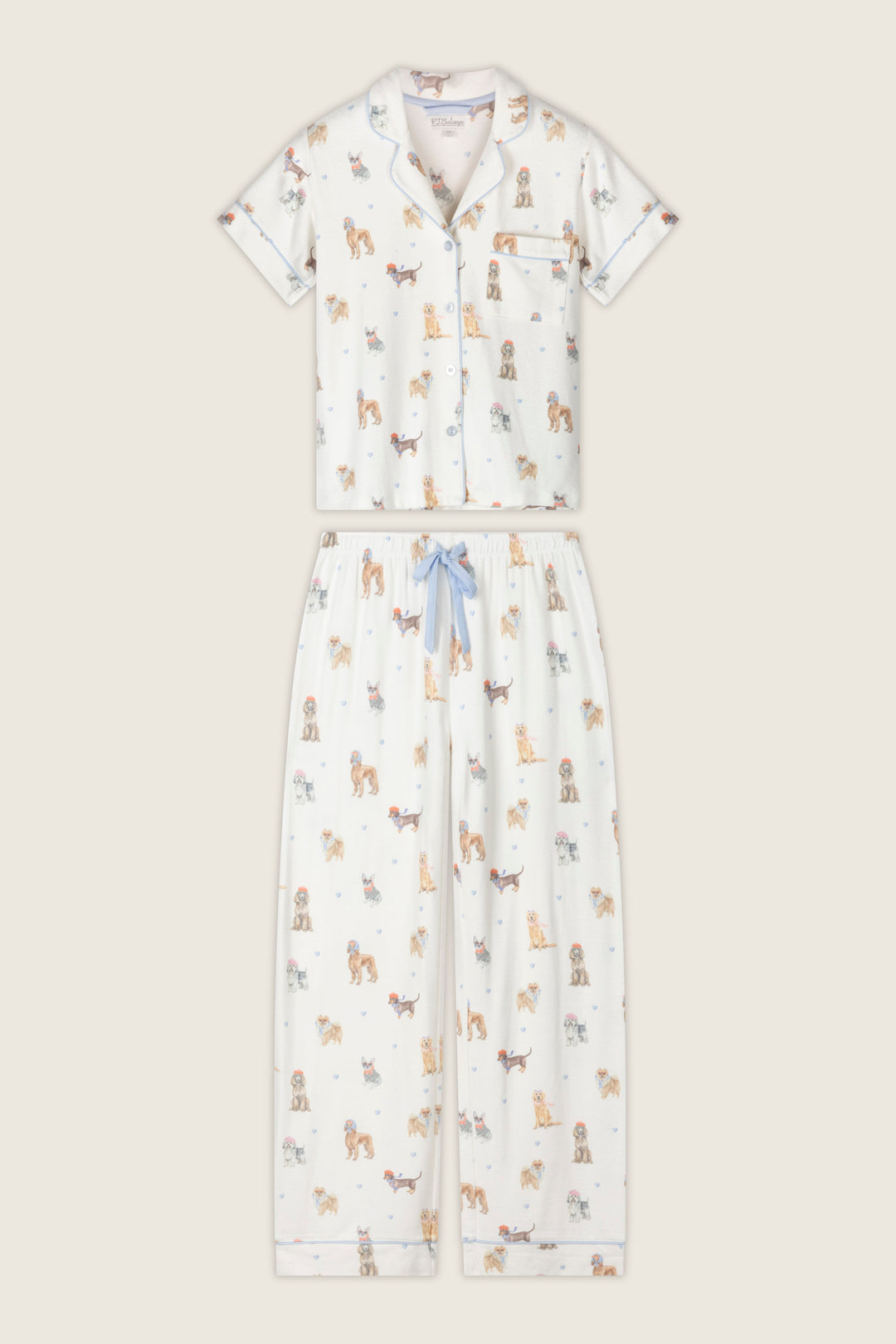 Sleep in style with the Meet Me in Pawris Dog Print 3-Piece PJ Set from P.J. Salvage, featuring a white short-sleeve button-up top with a chest pocket and playful, colorful cartoon dog prints all over. The matching pants include a blue drawstring for comfort, making this set both cute and cozy.