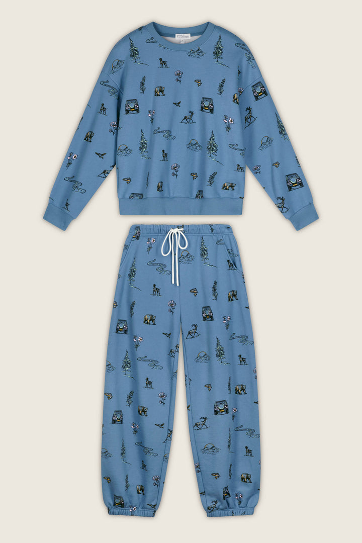 The P.J. Salvage Nature Is My Therapy Nature Print Frankie Sweatshirt features long sleeves and an all-over print of outdoor-themed illustrations, including trees, mountains, bears, and tents.