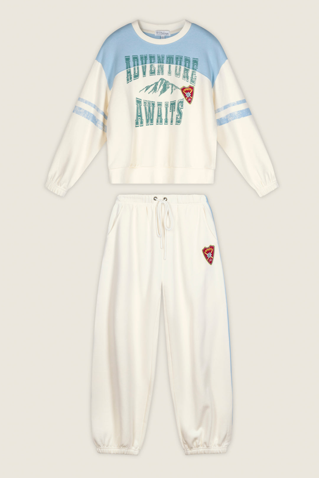 P.J. Salvage “Nature Is My Therapy Adventure Awaits Margaux” two-piece set featuring a cream and blue sweatshirt with “ADVENTURE AWAITS” above a mountain graphic, paired with coordinating cream sweatpants. Both pieces are accented with a small red embroidered mountain patch.