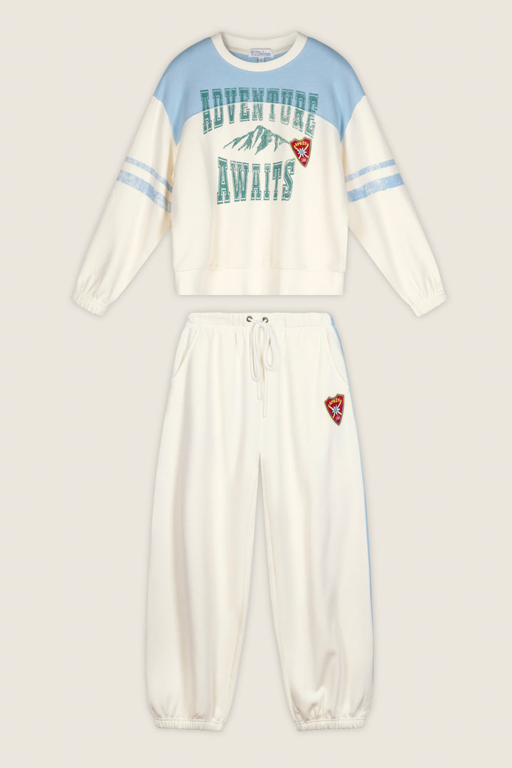 P.J. Salvage “Nature Is My Therapy Adventure Awaits Margaux” two-piece set featuring a cream and blue sweatshirt with “ADVENTURE AWAITS” above a mountain graphic, paired with coordinating cream sweatpants. Both pieces are accented with a small red embroidered mountain patch.