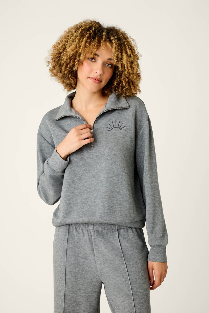 A person with curly hair wears the P.J. Salvage Nature Is My Therapy Wish You Were Here Over Night Pullover and matching pants, standing against a plain background and looking at the camera with a relaxed expression.