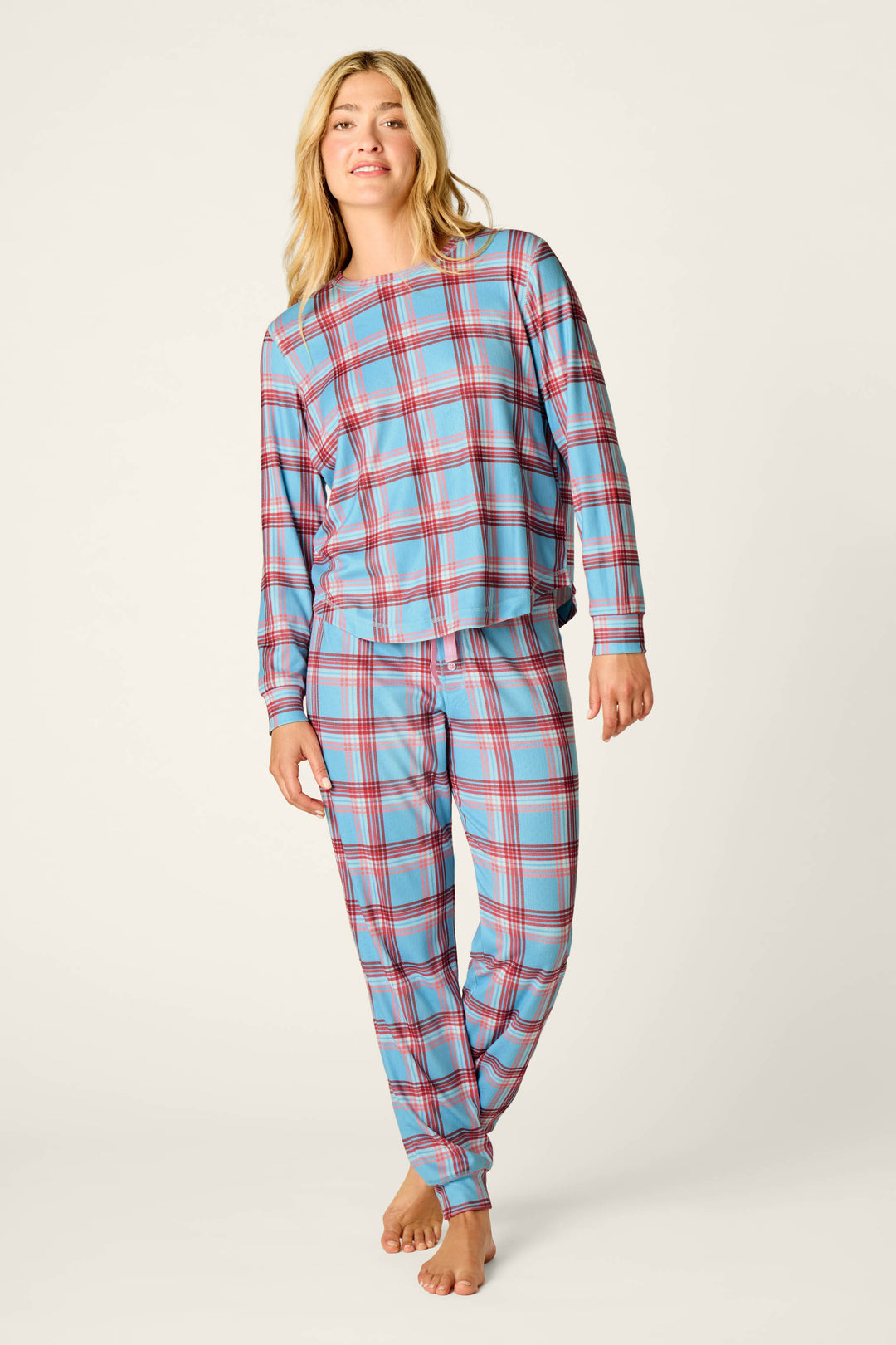 A person stands barefoot against a plain light background wearing P.J. Salvage’s Plaid About You Blue & Red Plaid Print Long Sleeve Top.