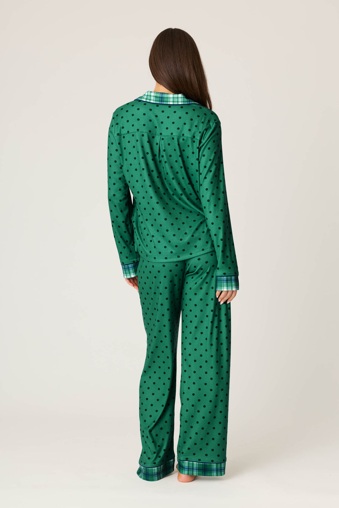 A person with long brown hair models the P.J. Salvage Plaid About You Polka Dots & Plaid PJ Set, standing with their back to the camera against a plain light background.