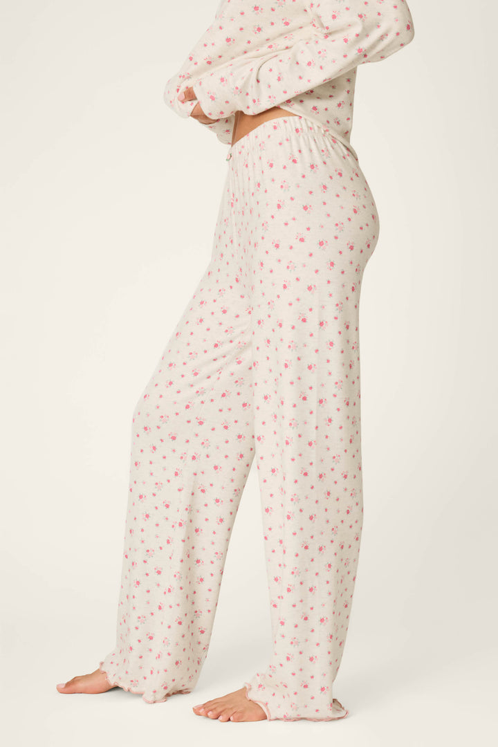 A person wearing P.J. Salvage Romantic Rose Ditsy Rose Print Pajama Pants, standing barefoot on a light background.