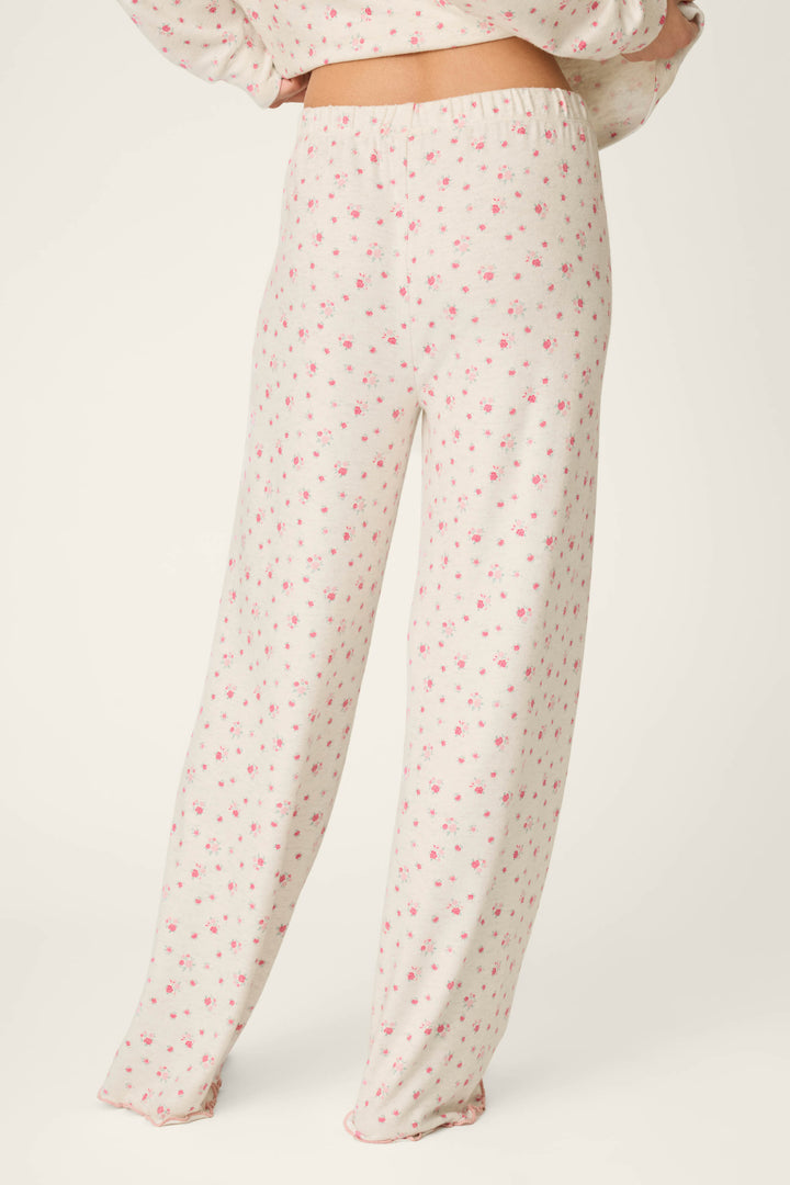 A person is wearing the P.J. Salvage Romantic Rose Ditsy Rose Print Pajama Pants, featuring a pink floral pattern, and is standing with their back to the camera against a plain light background.