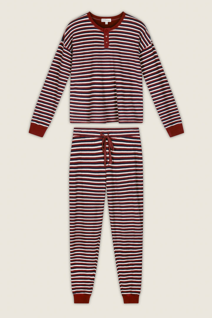 The Ski Jammie Classics Striped Long Sleeve Jogger PJ Set by P.J. Salvage is a coordinated pajama set with horizontal maroon and white stripes, featuring a buttoned top and drawstring jogger pants with maroon cuffs.