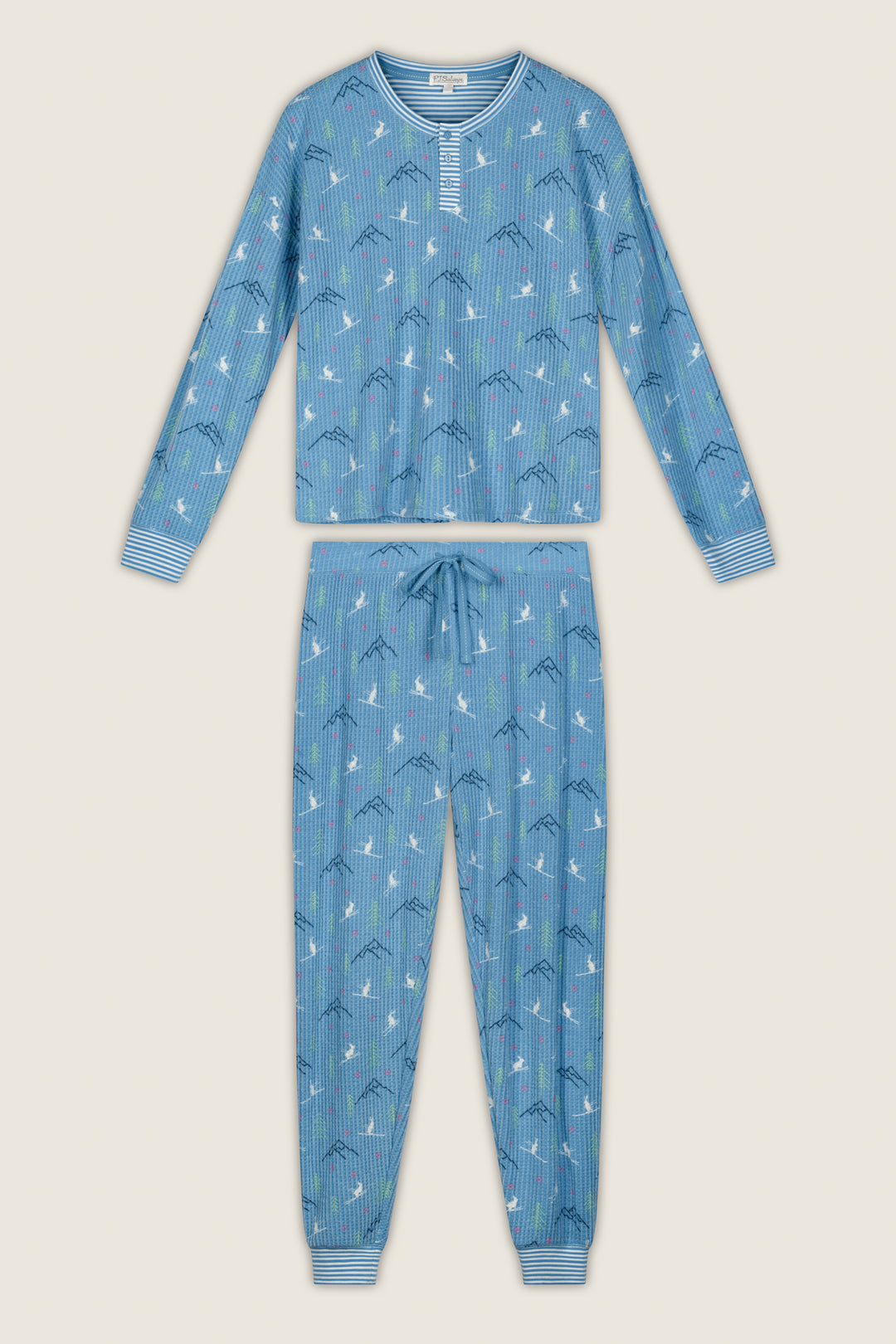 The P.J. Salvage Ski Jammie Classics Skiing Bunnies Long Sleeve Jogger PJ Set features a blue long-sleeve design with a drawstring waist, vertical stripes, and a playful print of clouds and mountain shapes. The cuffs are detailed with horizontal white and blue stripes.