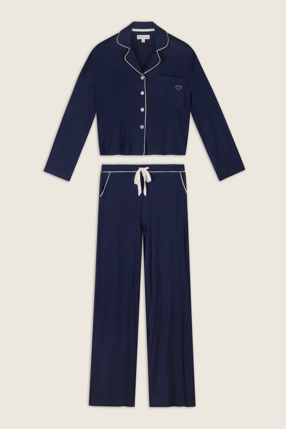 The Soiree Dreams Deep Navy Long Sleeve PJ Set by P.J. Salvage, featuring white piping, includes a button-up top with a front pocket and matching drawstring pants, displayed flat on a light background.