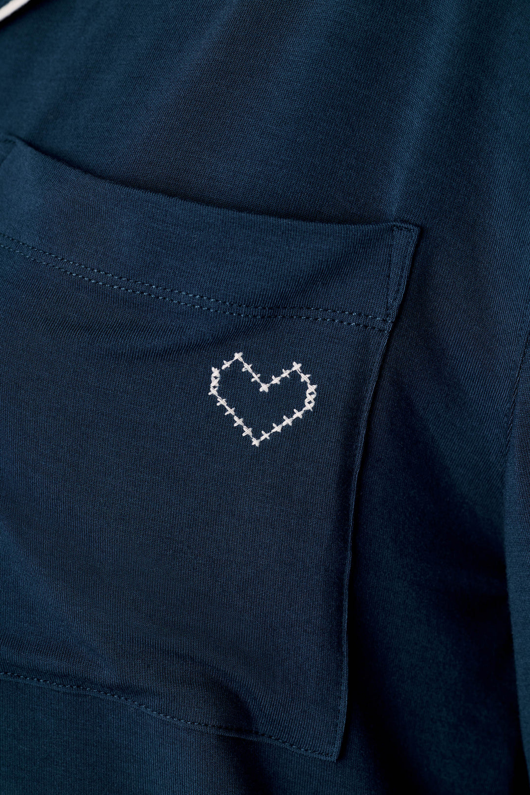 Close-up of the Soiree Dreams Deep Navy Long Sleeve PJ Set by P.J. Salvage, highlighting a small white stitched heart design on the shirt pocket.
