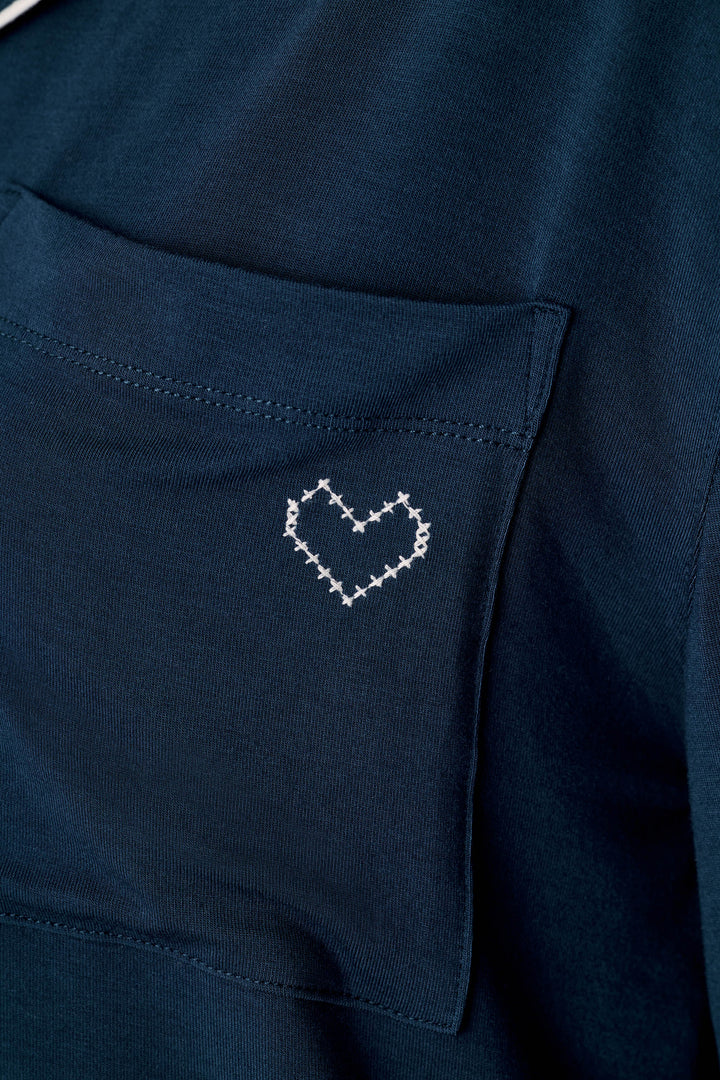 Close-up of the Soiree Dreams Deep Navy Long Sleeve PJ Set by P.J. Salvage, highlighting a small white stitched heart design on the shirt pocket.