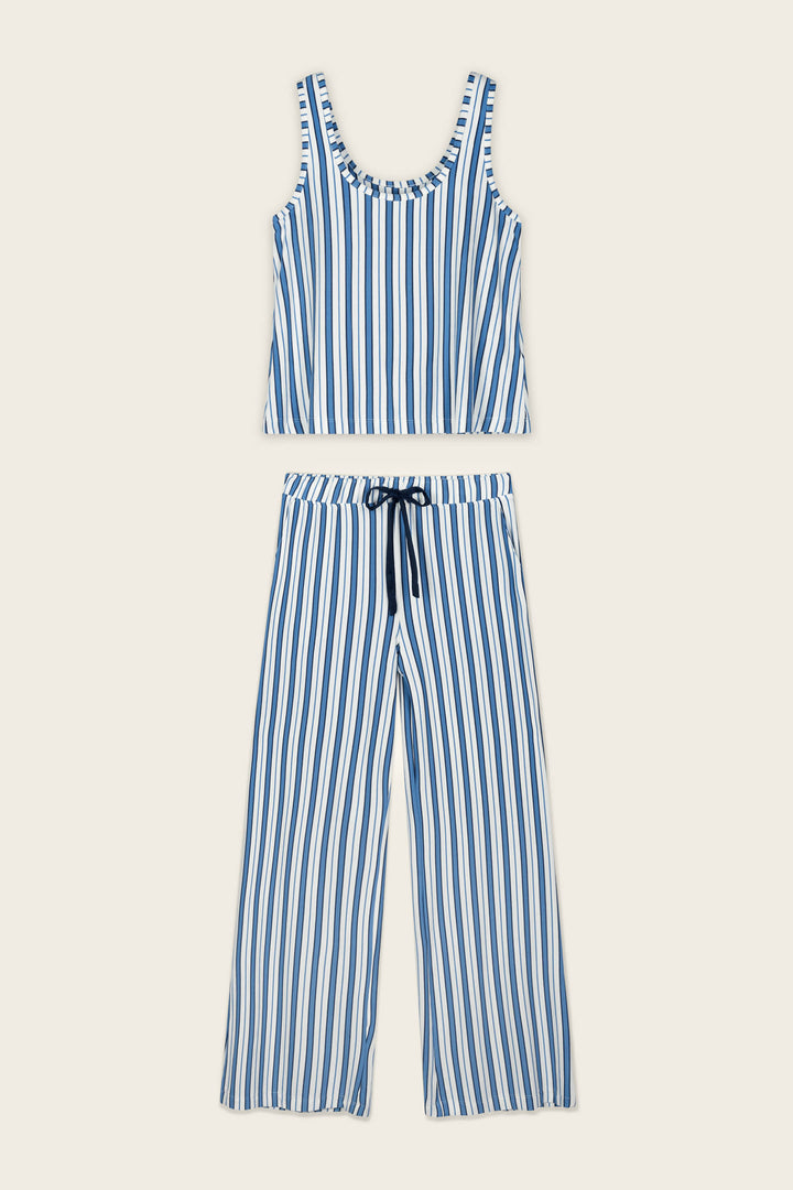 The Soiree Dreams Blue Stripe Tank & Pants PJ Set by P.J. Salvage, featuring a blue and white vertically striped sleeveless tank top and matching wide-leg pants with a drawstring waist, is laid flat on a beige background.