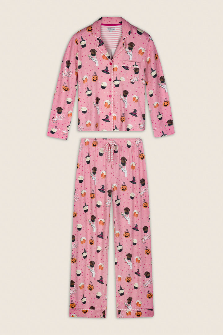 The Sweet and Spooky Halloween Print Long Sleeve PJ Set by P.J. Salvage features a pink button-up top and pants decorated with playful cartoonish Halloween motifs, including jack-o-lanterns, witches, and black cats, for a fun and festive look.
