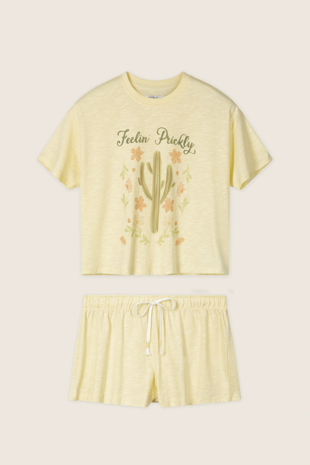 The P.J. Salvage Softee "Feelin' Prickly" Graphic Print Short PJ Set features a light yellow relaxed fit with a cactus design crop top reading "Feelin' Prickly" and comfy shorts with an elastic waistband and drawstring.