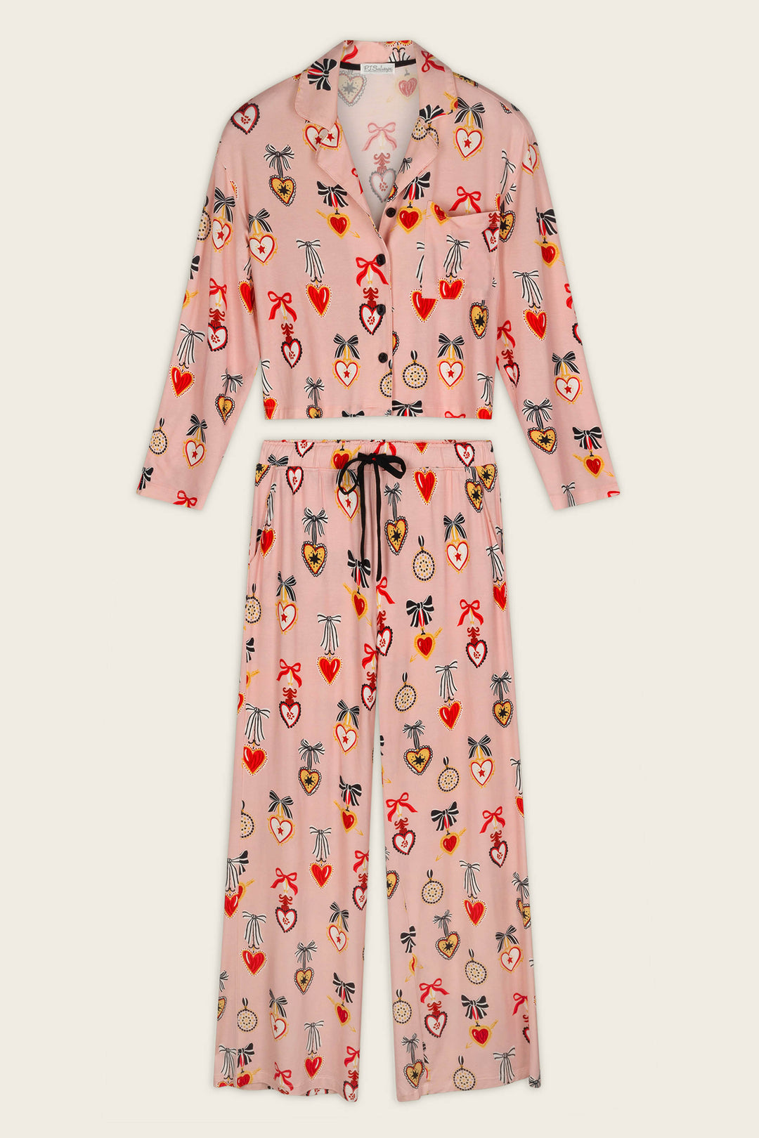 P.J. Salvage Sweetheart Dreams Love Lockets Print Long Sleeve PJ Set features a pink pajama set with a button-up long-sleeve top and pants, adorned with colorful hearts, bows, and floral motifs. The pants include a black drawstring waist for added comfort.