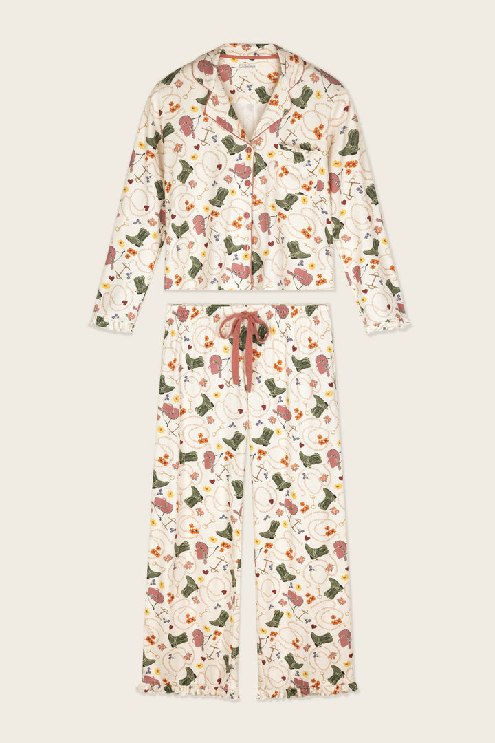 The Saddle Up Western Print Long Sleeve PJ Set by P.J. Salvage is a matching pajama set with a long-sleeve, button-up top and drawstring pants, featuring a western-inspired print.