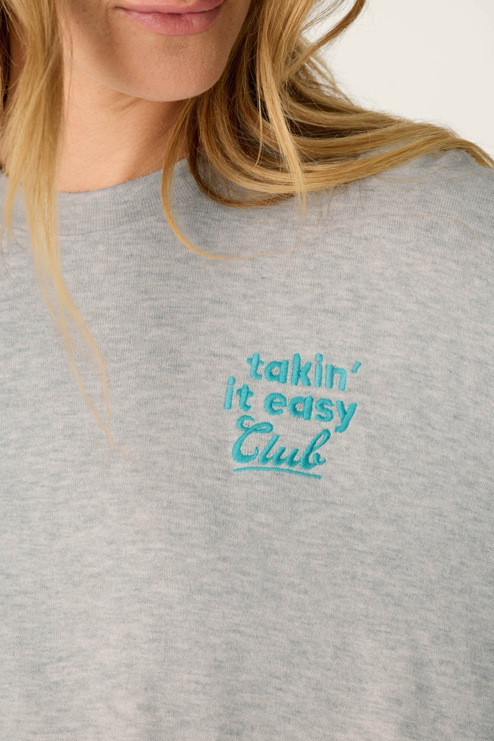 A person with long blonde hair wearing the P.J. Salvage Takin’ It Easy Club Striped Long Sleeve Top.