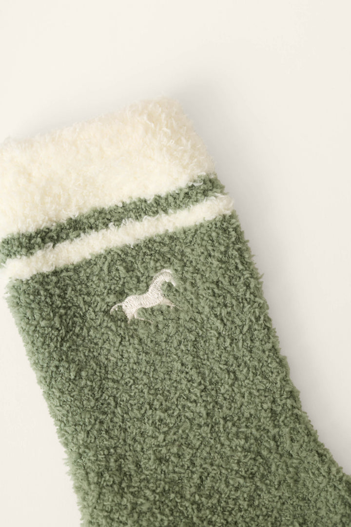 The Wild Mustang Army Green Socks by P.J. Salvage feature a fuzzy green design with a white cuff, white stripes, and a small white embroidered horse near the top.