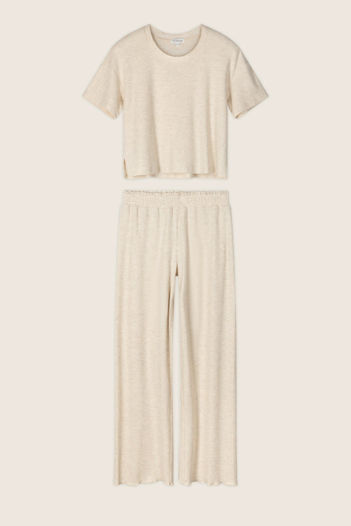 The P.J. Salvage Weekend Waffles Light Oatmeal Long PJ Set includes a short-sleeve, crew-neck crop top and high-waisted, wide-leg pants in soft waffle fabric—ideal for cozy nights—shown against a neutral background.