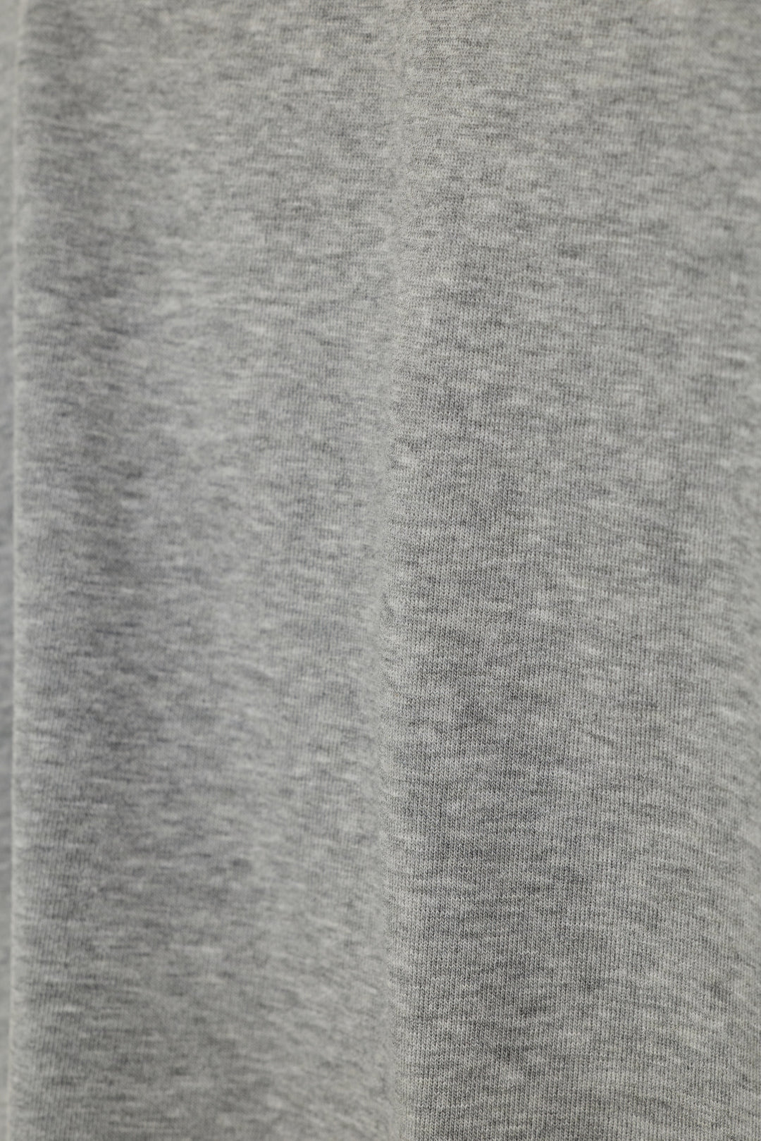 Close-up of a heather gray knit fabric texture with soft vertical folds.