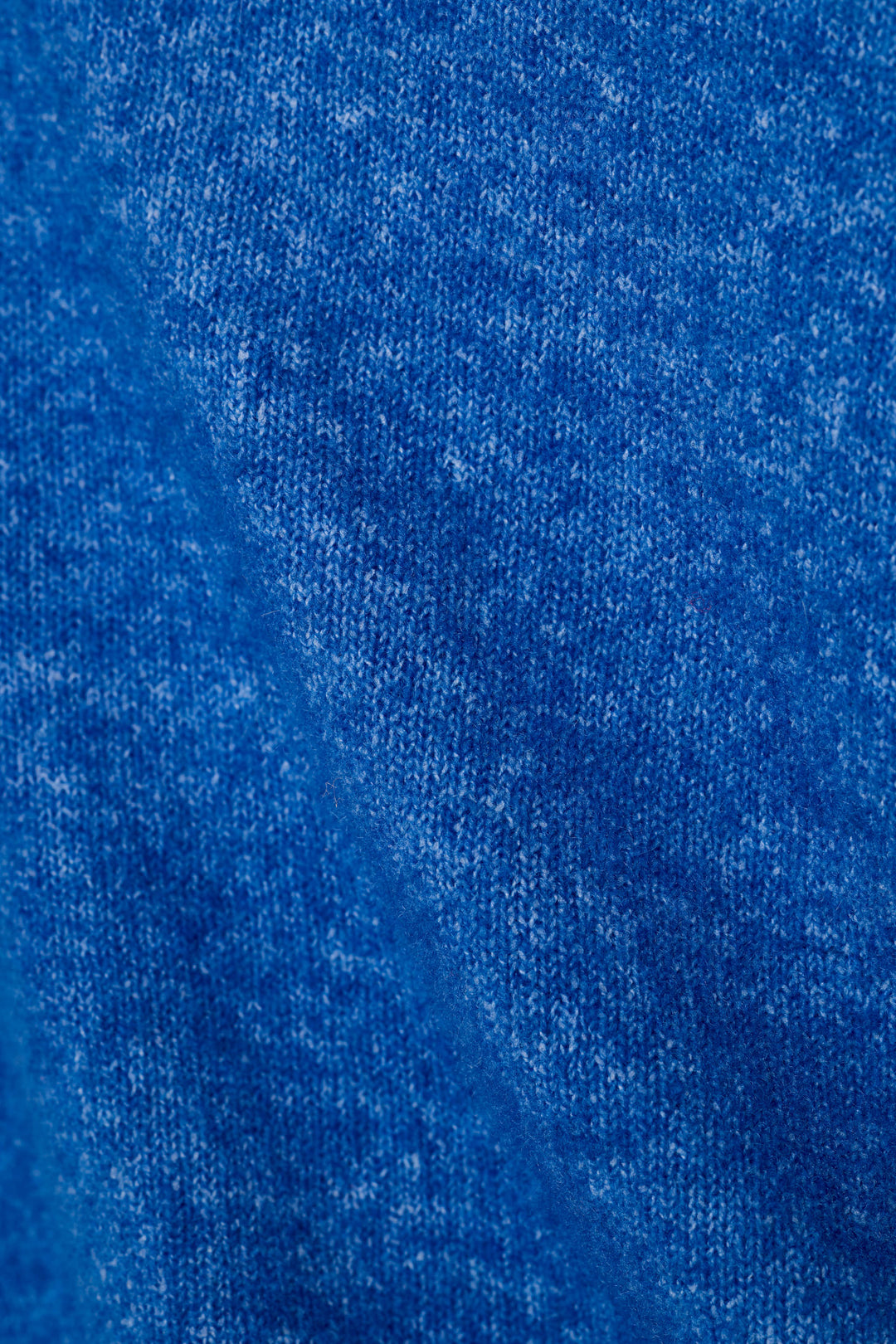 A close-up of a heathered royal blue sweater fabric texture, showing the detailed weave and color variation.