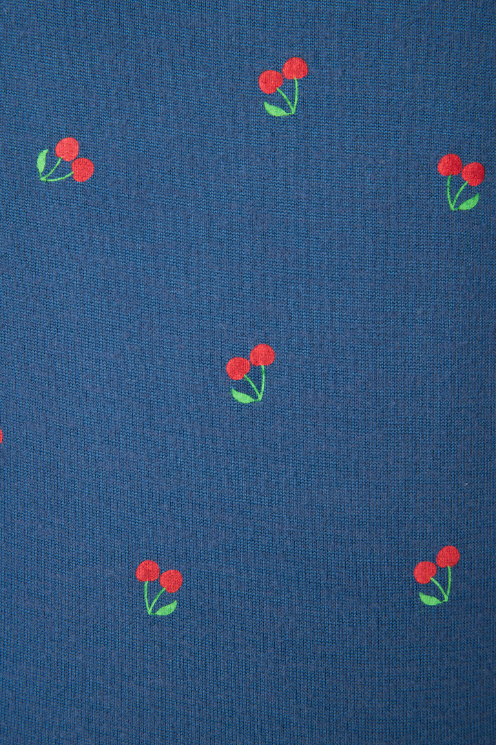 Blue fabric with a repeating pattern of small red cherries and green leaves, evenly spaced across the surface.