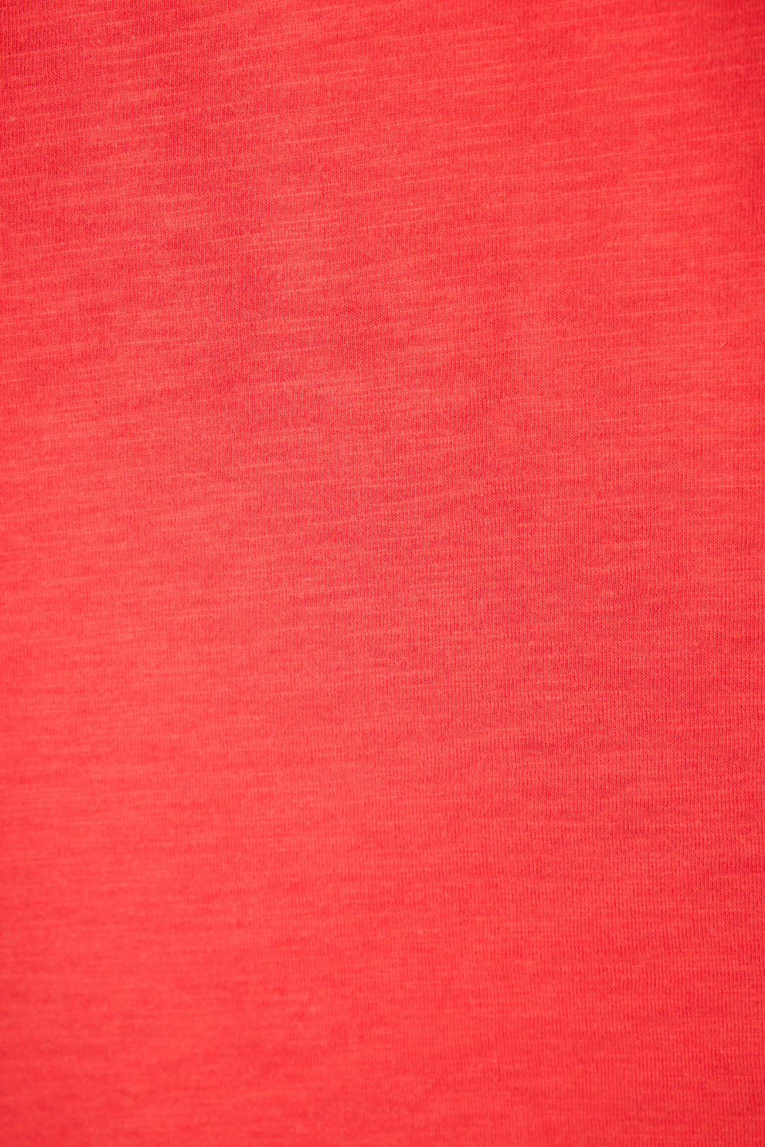 A close-up of textured red fabric with subtle shading and a distinct weave pattern.