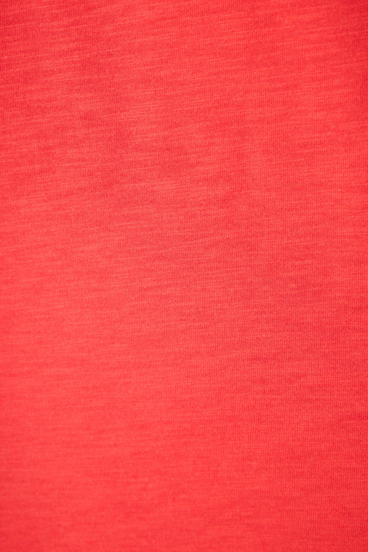 A close-up of textured red fabric with subtle shading and a distinct weave pattern.