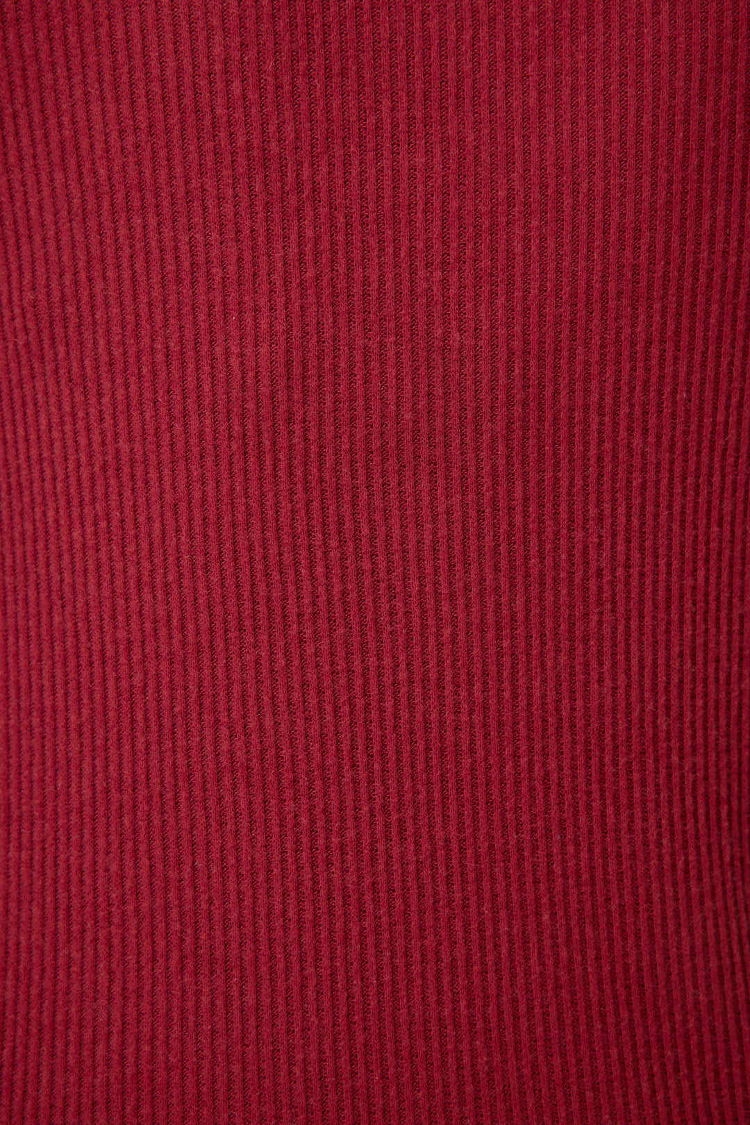 Close-up of textured red cotton-blend jersey fabric with vertical ribbed lines.