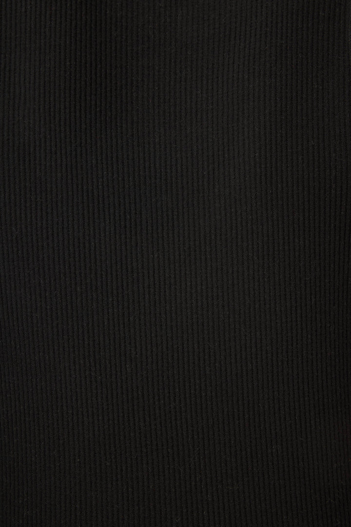 A close-up of the black ribbed fabric texture from Textured Essentials by P.J. Salvage, showcasing vertical lines and soft folds.