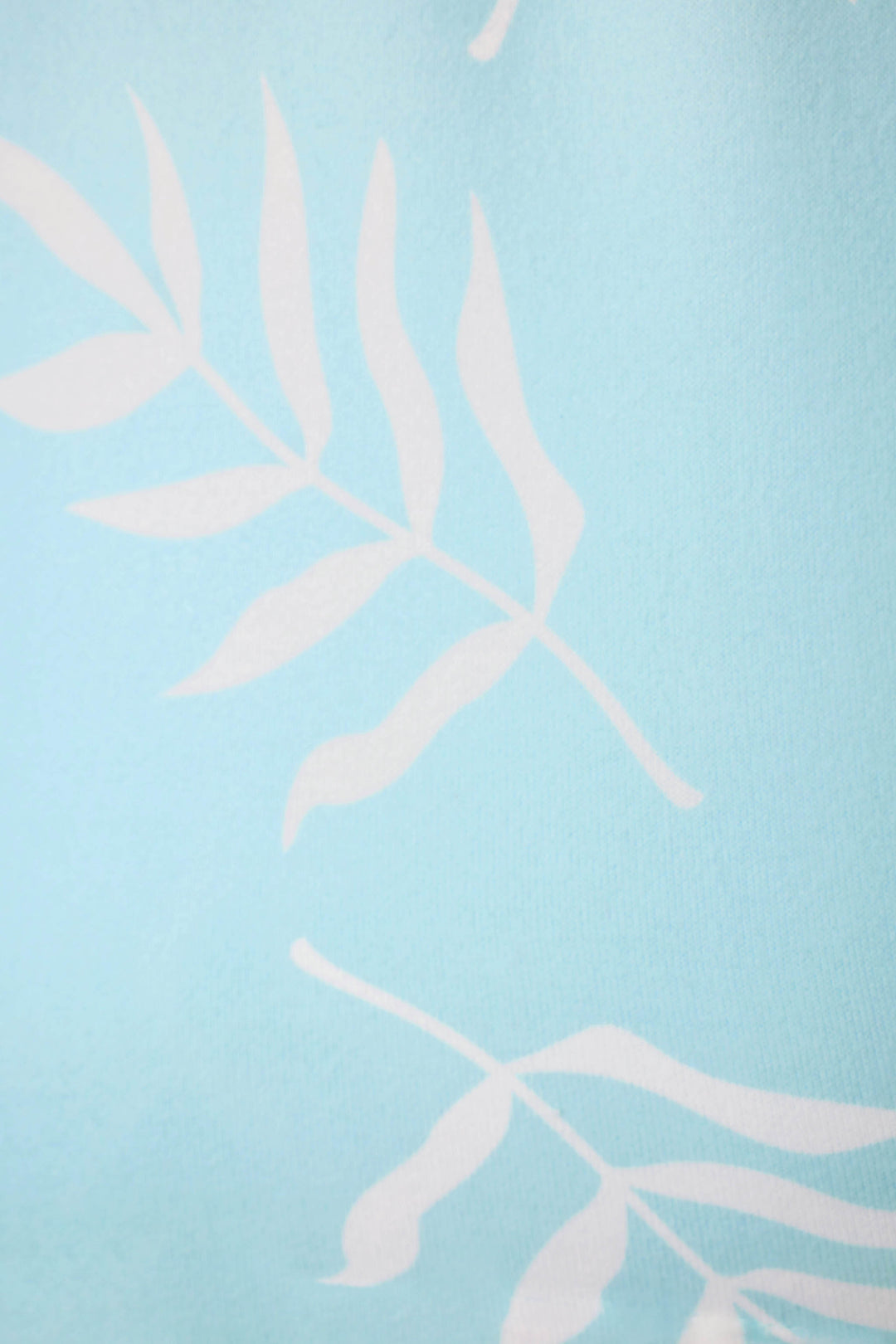Light blue fabric with a simple white leaf pattern of long stems and elongated leaves repeated across the surface.