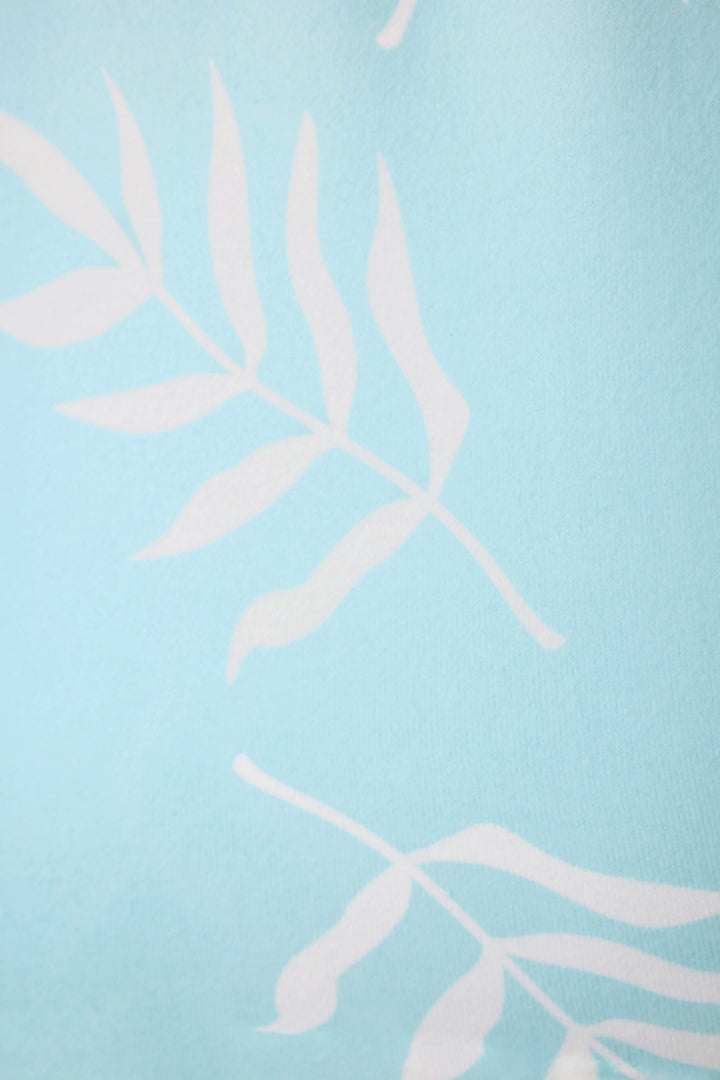 Light blue fabric with a simple white leaf pattern of long stems and elongated leaves repeated across the surface.